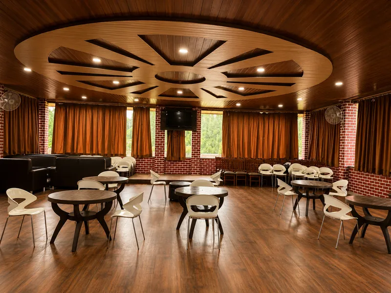 The party hall laid out with round tables and white chairs